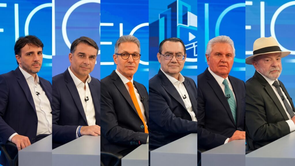 Composição fotográfica em seis painéis verticais com cenário azul de debate eleitoral, exibindo, da esquerda para a direita: Renan Santos, Flávio Bolsonaro, Romeu Zema, Augusto Cury, Ronaldo Caiado e Luiz Inácio Lula da Silva de fato escuro e chapéu Panamá.